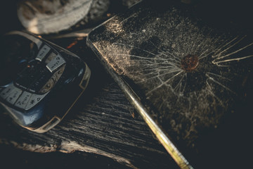 Old cellphones, broken smartphone with Broken Display nailed by a nail