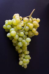 sweet big bunch of green grapes on black vertical background wine agriculture concept