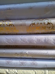 Rolls of beautiful oilcloth on the table close-up.