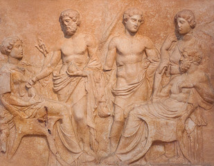 Ancient funerary stele from Kerameikos in Athens, Greece depicting man and woman sit faced each other and tree more figures, two men and a women stand in background