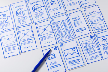 User experience design, desk with paper sketches for mobile interface - obrazy, fototapety, plakaty