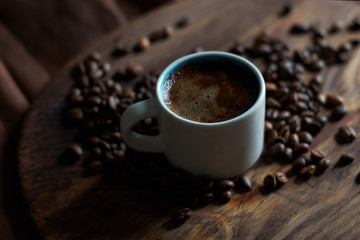 White cup with coffee and coffee grains