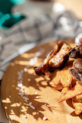 food photography grilled meat French fries in the cafe a bright Sunny natural light and shadow from the leaves of plants