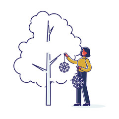 Woman decorating garden for christmas and new year holidays. Female put snowflakes on trees