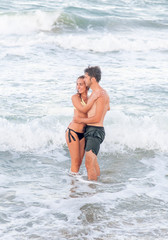 Summer vacation concept. Young woman and man hugging in the sea
