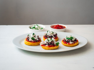 Sopes also known as Picadita, Traditional Mexican Dish That Looks like an Unusually Thick Tortilla with Toppings like Tomato Sauce, Refried Beans, Raw Onion, Cilantro