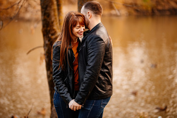 Fototapeta premium man and woman flirt in autumn park near river.
