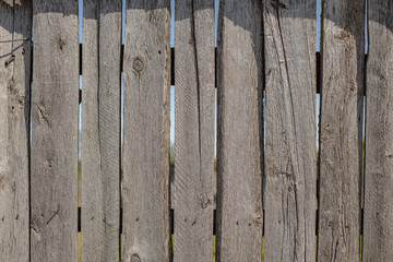 fence made of old wooden boards, texture of old, cracked boards, wooden background
