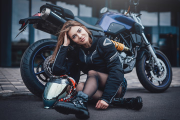 A nice looking woman at the streets with her urban sport motorcycle. Motorbike sport hobby. Modern custom bike.
