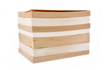 Stack of multiple old and yellowed stacked paperback books isolated on white background