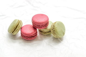 raspberry and pistachio macaroon cakes on on white parchment
