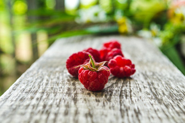 Raspberries on a wooden bench in the village
