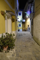 Fototapeta na wymiar A narrow street between the old houses of San Nicola Arcella, a village in the region of Calabria, Italy.