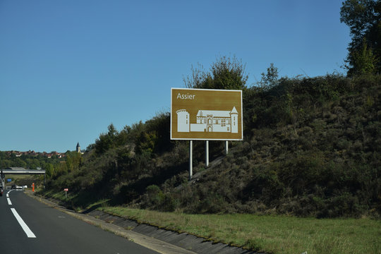 En roulant : panneau touristique sur autoroute A20. Assier, Lot, Occitanie, France.