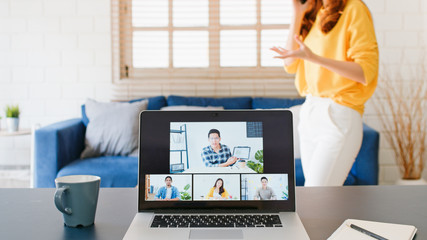 Young Asian woman on mobile phone call during video call conference, online remote meeting with...