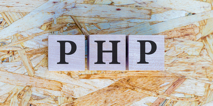The inscription PHP on wooden blocks on wooden background. Letter text on wooden cube.