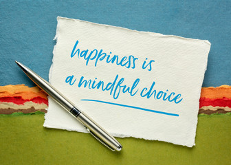 happiness is a mindful choice inspirational note on a sheet of white Khadi rag paper against colorful abstract landscape, mindfulness and personal development concept