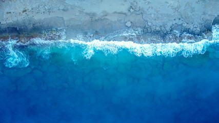 Aerial view at the sea with waves at a sunrise. Directly above the sea camera.