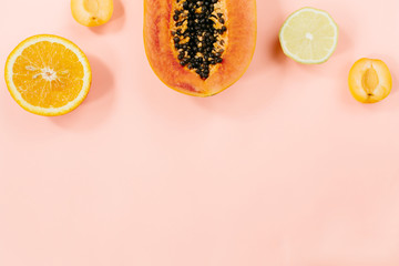 Summer tropical composition. Tropical fruits (Papaya, orange, lemon, peach) on pink background. Summer concept. Flat lay, top view, copy space