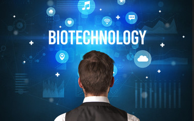 Rear view of a businessman with BIOTECHNOLOGY inscription, modern technology concept