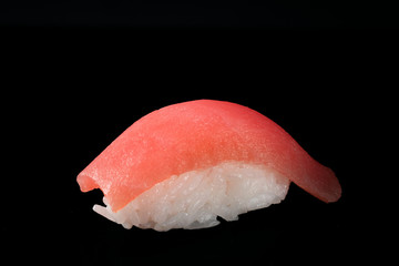 One Japanese fresh sushi nigiri with tuna isolated on a black background