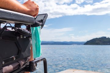 Fototapeta premium Coronavirus face mask on wheelchair to be used for protection and hygiene.
