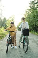 Fototapeta premium Happy young mother in casualwear and sunglasses and her youthful son in helmet