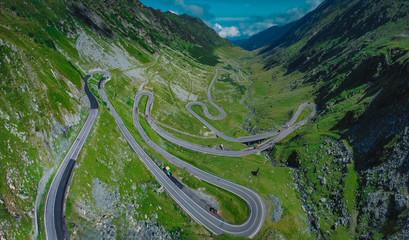 Epic winding road on Transfagarasan pass in Romania in summer time, with twisty road rising up....