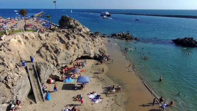 gorgeous aerial shot of the blue waters, boats and yachts, and people relaxing at Corona Del Mar Beach in Newport Beach California USA