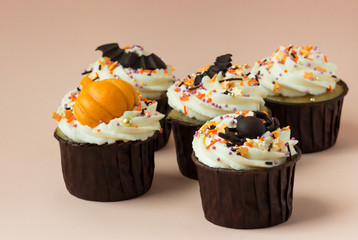 Halloween cupcakes  pumpkin, spiders, bat on a pink background.