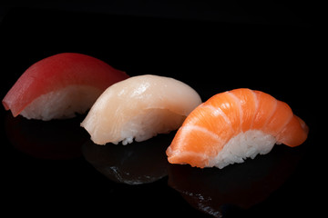 Set of various classic nigiri sushi isolated on black background © Andrey