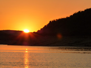 sunset in the river with mountains