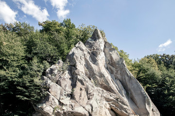 Russia city resort. People sail in a rowboat along the river against the mountain rock Cockerel on a sunny summer day.