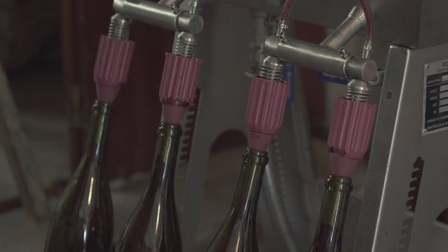 Close up on a vintage wine bottle filling process, small traditional winery
