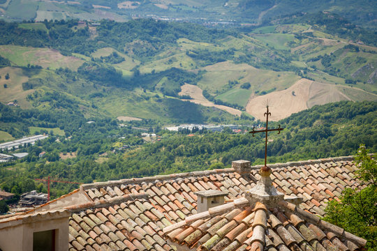 Old Ceramic Tile, roof. View of the surroundings of the Republic of San Marino. Chimneys and stormwater, lightning rods. mountains and fields in the background. Italy