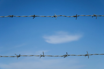 barbed wire against blue sky