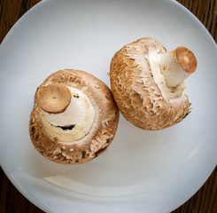 Two portobello mushrooms on a small white plate