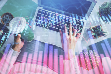 Double exposure of woman hands working on computer and forex chart hologram drawing. Top View. Financial analysis concept.