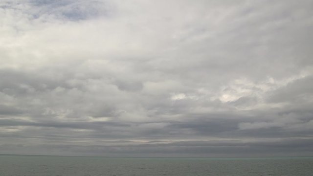 Grey sky low clouds cumulous stratus over green blue aqua calm lake storm Lake Huron Ontario Chantry static