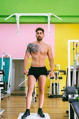 Fototapeta premium Handsome, sexy, topless, shirtless man standing at gym while looking aside
