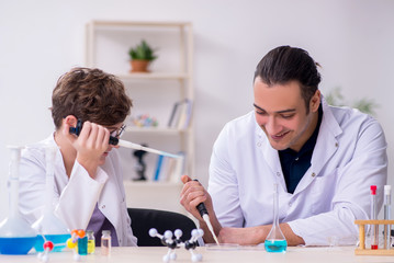 Fototapeta premium Young father and son chemists in the lab