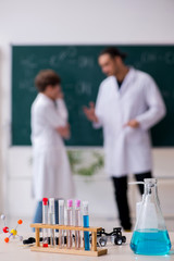 Young chemistry teacher and schoolboy in the classroom