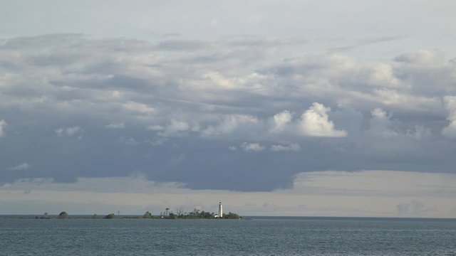 Morning Skyline with thick clouds rolling over Island lighthouse forest trees static Lake Huron daytime Ontario painting chantry