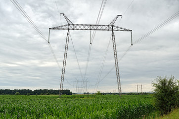Fototapeta na wymiar Supports of high voltage lines in the field