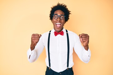 Handsome african american man with afro hair wearing hipster elegant look celebrating surprised and...