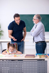 Young parent, old male teacher and little girl in the classroom