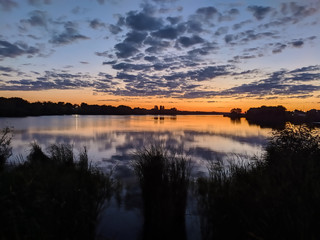 Sunbeams at sunset are reflected in the lake