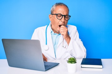 Senior handsome man with gray hair wearing doctor uniform working using computer laptop feeling unwell and coughing as symptom for cold or bronchitis. health care concept.