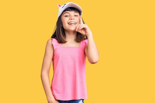 Young little girl with bang wearing funny kitty cap pointing finger up with successful idea. exited and happy. number one.