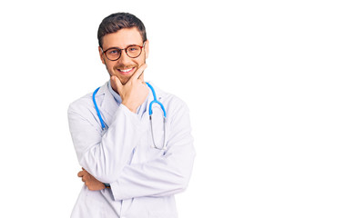 Fototapeta premium Handsome young man with bear wearing doctor uniform looking confident at the camera smiling with crossed arms and hand raised on chin. thinking positive.